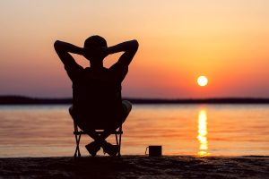 Person relaxing by the lake on vacation